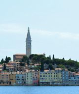 Blick auf bunte Häuser am Wasser und einen Kirchturm nahe Novigrad, einer Stadt in Istrien, Kroatien.