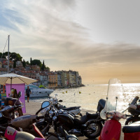 Abendliche Hafenansicht nahe Novigrad, Istrien, Kroatien mit Motorrollern, Booten und malerischer Altstadt.