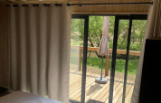 Gezellige slaapkamer met houten plafond, schuifdeur naar het terras bij Cocoon de l’Ourthe, België.