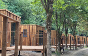 Cabanes en bois en forêt à l’Eco Lodge du Hameau de l’Ourthe, Belgique, vues du sentier forestier.