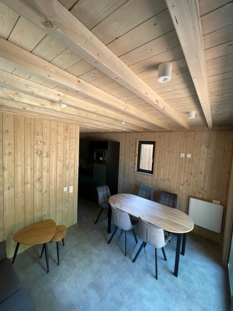 Interieurfoto van een met hout beklede Eco Lodge bij Hameau de l'Ourthe in België met eettafel en stoelen.
