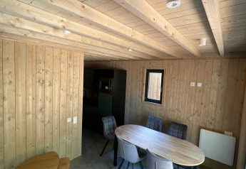 Interieurfoto van een met hout beklede Eco Lodge bij Hameau de l'Ourthe in België met eettafel en stoelen.