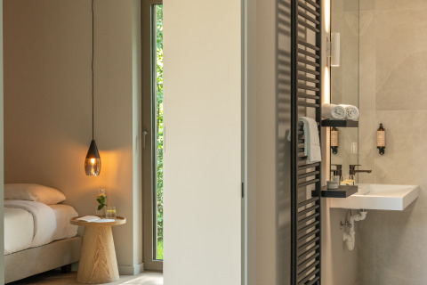 Lodge moderno con dormitorio acogedor y elegante baño con toallas y artículos de tocador de lujo en estantes.