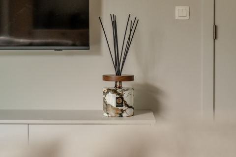 Marble fragrance diffuser with black sticks on white cabinet in Suite Accessible at Woodz Lodges, Belgium.