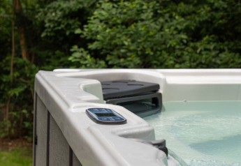 Buitenjacuzzi bij Lodge with Jacuzzi in Woodz Lodges België, met het bedieningspaneel op de rand.