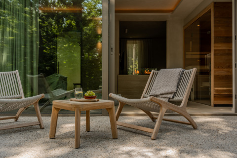 Terrace at the Wellness Suite, Woodz Lodges in Belgium, featuring modern lounge chairs and a wooden table.