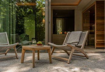 Terras bij de Wellness Suite van Woodz Lodges in België met moderne loungestoelen en houten tafel.