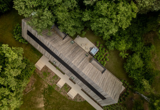 Aerial view of the Wellness Suite at Woodz Lodges in Belgium, surrounded by lush trees and greenery.
