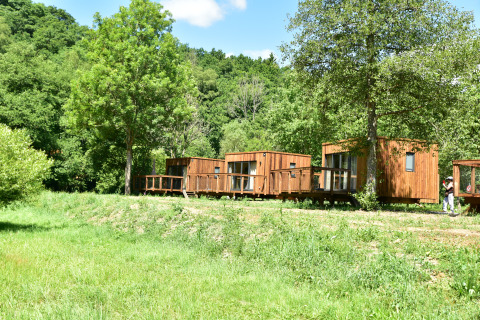 Cabanes en bois du Cocoon de l'Ourthe au Hameau de l'Ourthe, Belgique, au cœur d'une nature verdoyante.
