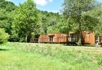 Træhytter på Cocoon de l'Ourthe lodge i Hameau de l'Ourthe, Belgien, omgivet af grøn natur og skov.