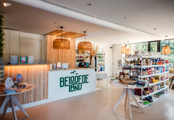 Binnenkant van een safaritentwinkel met houten inrichting, gevulde rekken en grote raampartijen.