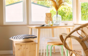 Rincón comedor iluminado en tiny house de Zomerhuisjes, Beloofde Land, Países Bajos, con muebles de madera.