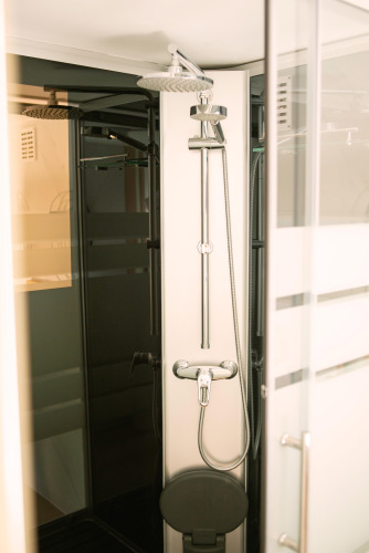 Ducha moderna en casa pequeña de Zomerhuisjes, Beloofde Land, Países Bajos, con puerta de cristal.