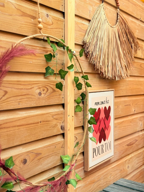 Clôture en bois décorée de guirlande feuillue, déco murale, et affiche française de cœurs dans un lodge douillet.