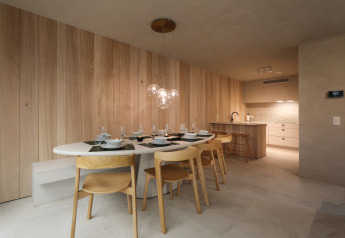 Zona pranzo moderna con cucina in legno chiaro al Group Lodge presso Woodz Lodges in Belgio.