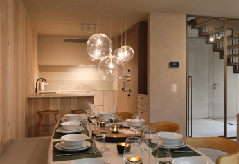 Moderne spise- og køkkenområde på Group Lodge ved Woodz Lodges i Belgien med stilfuld belysning.