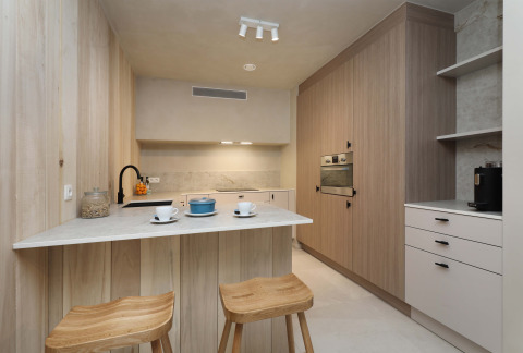 Cocina moderna en Group Lodge de Woodz Lodges en Bélgica, con encimeras de madera y taburetes altos.