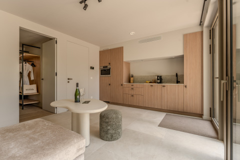 Soggiorno moderno con cucina aperta e arredo elegante al Group Lodge presso Woodz Lodges in Belgio.