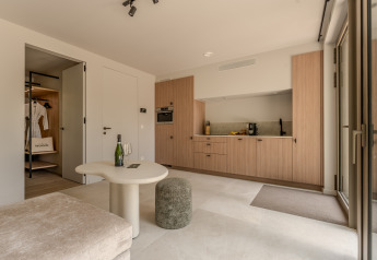 Soggiorno moderno con cucina aperta e arredo elegante al Group Lodge presso Woodz Lodges in Belgio.