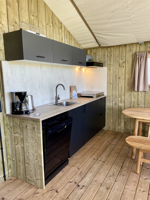 Modern kitchenette in the Luna Lodge safari tent at Camping the Noetselerberg in the Netherlands with wood decor.