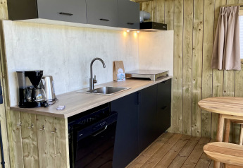 Angolo cottura moderno nella tenda safari Luna Lodge al Camping the Noetselerberg nei Paesi Bassi con arredamento in legno.