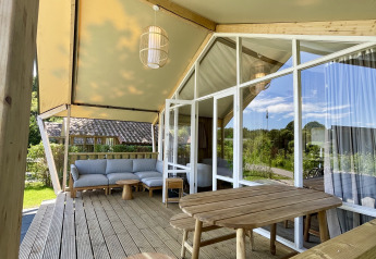 Terrazza in legno con arredi rustici nella tenda safari Luna Lodge, Camping Noetselerberg, Paesi Bassi.