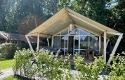 Safari tent Luna Lodge at Camping the Noetselerberg in the Netherlands, surrounded by greenery and sunlight.