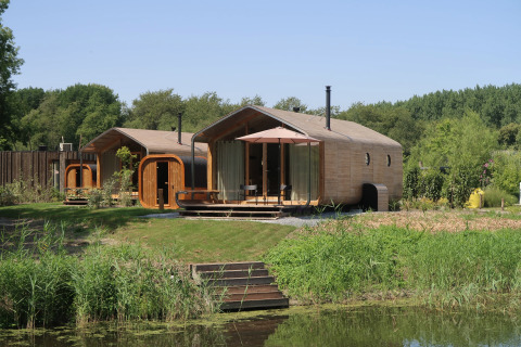 Wrap house met sauna en bad bij Resort de Parel, omringd door natuur in Nederland.