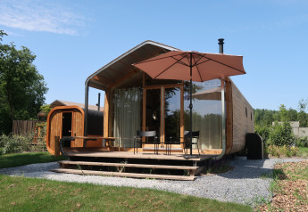 Wrap house lodge with sauna, bathtub, and patio deck at Resort de Parel, surrounded by nature in the Netherlands.