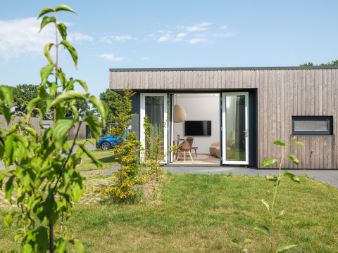 Moderne Holz-Lodge namens Oak Lodge im Vakantiepark Hölte, Niederlande, mit offenem Wohnbereich.