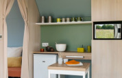 Interieur van Coco Sweet safaritent bij Camping Seasonova Haliotis, Frankrijk, met compacte keukenhoek.
