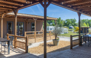 Espace extérieur à Tiny Wander Lodge au Holiday Park Sallandshoeve, Pays-Bas, avec vue sur caravanes et verdure.