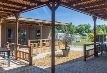 Espace extérieur à Tiny Wander Lodge au Holiday Park Sallandshoeve, Pays-Bas, avec vue sur caravanes et verdure.