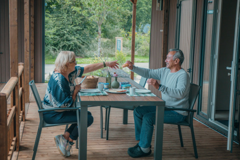 Deux personnes prennent le petit-déjeuner sur la terrasse de Tiny Wander Lodge à Holiday Park Sallandshoeve, Pays-Bas.