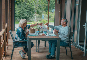 Deux personnes prennent le petit-déjeuner sur la terrasse de Tiny Wander Lodge à Holiday Park Sallandshoeve, Pays-Bas.