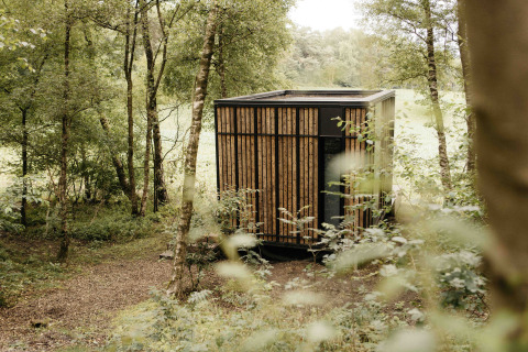 Tiny house moderna Nokken NKN-18 Cabin a Wilsumer Berge, Germania, immersa nella natura lussureggiante del bosco.