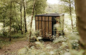 Moderne tiny house Nokken NKN-18 Cabin in Wilsumer Berge, Duitsland, omgeven door groen en bosrijke natuur.
