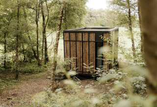 Modern tiny house Nokken NKN-18 Cabin at Wilsumer Berge, Germany, surrounded by lush, green forest nature.