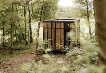 Tiny house moderna Nokken NKN-18 Cabin a Wilsumer Berge, Germania, immersa nella natura lussureggiante del bosco.