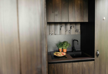 Petite cuisine moderne dans la Nokken NKN-18 Cabin à Wilsumer Berge, Allemagne, avec herbes et légumes.