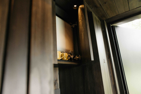 Open kitchen cabinet in Nokken NKN-18 Cabin at Wilsumer Berge, Germany, featuring mugs and glasses.