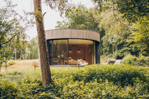 Rond tiny house LumiPod met grote ramen en hottub, gelegen in het bos bij Wilsumer Berge, Duitsland.