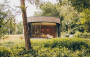 Ronde tiny house LumiPod met glazen wand en hottub in de bossen van Wilsumer Berge, Duitsland.