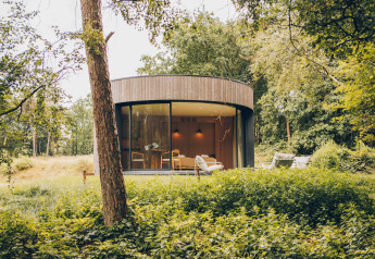 Tiny house rotonda LumiPod con vetrate e vasca idromassaggio nella foresta di Wilsumer Berge, Germania.