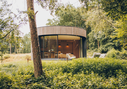 Rond tiny house LumiPod met grote ramen en hottub, gelegen in het bos bij Wilsumer Berge, Duitsland.