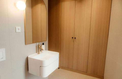 Modernes kleines Badezimmer in LumiPod mit Waschtisch, Spiegel und Holzschränken, Wilsumer Berge, Deutschland.