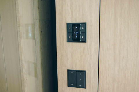 Moderne bedieningspanelen aan muur in LumiPod tiny house bij Wilsumer Berge, Duitsland, nabij hottub.