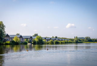 Lodge moderni lungo un lago tranquillo al Familievakantiepark Krieghuusbelten, Overijssel, Paesi Bassi.