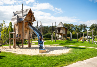 Parque infantil con casitas de madera y tobogán en Krieghuusbelten, parque vacacional en Overijssel, Países Bajos.