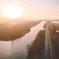 Lever de soleil sur une rivière et une route près de Raalte, Overijssel, Pays-Bas, vue aérienne embrumée.